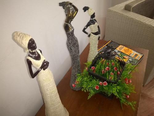 three statues of women sitting on a table at Santa Alejandría Hotel in Cartagena de Indias