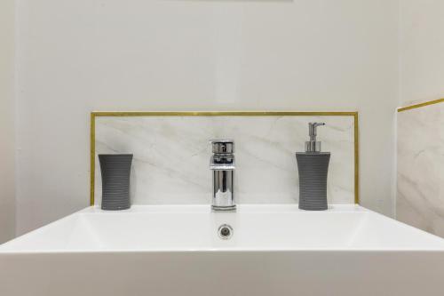 un lavabo con dos grifos encima en Accudo House Boutique Holiday Suites, en Portsmouth
