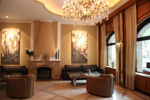 a living room with a chandelier and a fireplace at Hotel Coellner Hof in Cologne
