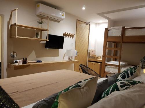 Schlafzimmer mit einem Bett, einem Schreibtisch und Etagenbetten in der Unterkunft Treevana Club Chiangmai in Chiang Mai