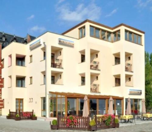 a large white building with a cafe in front of it at Pension Oderblick in Frankfurt Oder