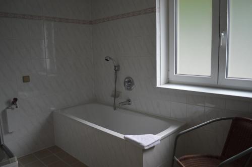 a white bath tub in a bathroom with a window at Jaeger Guesthouse in Annenheim