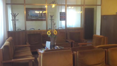 a waiting room with chairs and a table with flowers at Hotel Belvedere in Castrocaro Terme
