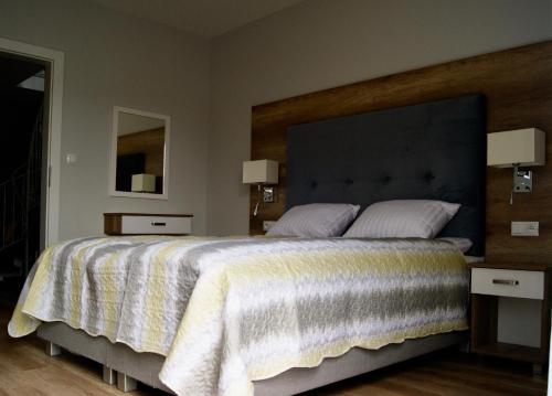 ウストロニエ・モルスキエにあるBumerangのベッドルーム1室(大型ベッド1台、ナイトスタンド2台付)