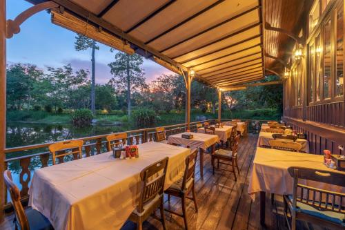 a restaurant with tables and chairs on a balcony at Vana Varin Resort in Hua Hin