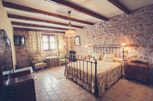 a bedroom with a bed in a room with stone walls at Hotel Mesón de Don Quijote in Mota del Cuervo