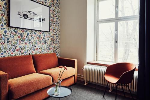 a living room filled with furniture and a window at NOFO Hotel, WorldHotels Crafted in Stockholm