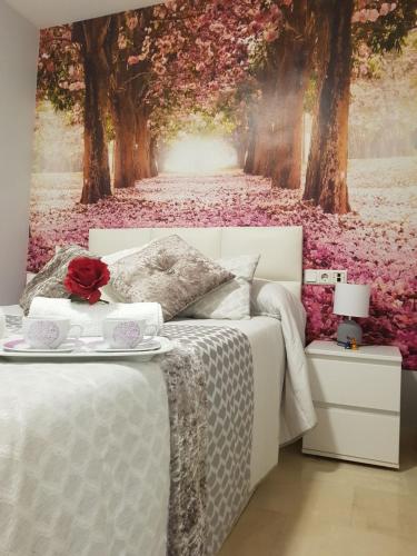 a bedroom with a bed with a wall mural of trees at Apartamento Ciudad del Tajo in Ronda