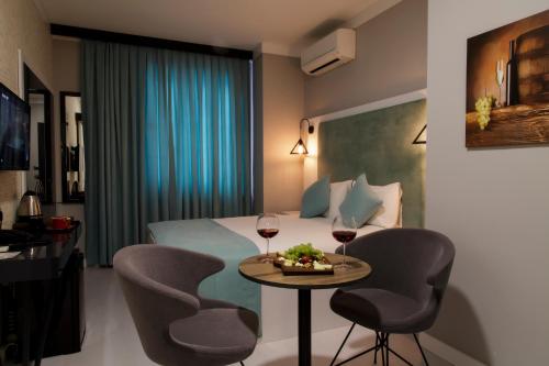 イスタンブールにあるBakırköy DES Suit Otelのベッド1台とワイン2杯が備わるホテルルームです。
