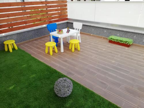a patio with two chairs and a table and some grass at Apartments Villa Katija in Drvenik