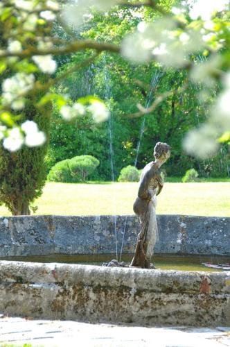 a statue of a boy standing in a fountain at Domaine de Rennebourg in Saint Denis Du Pin
