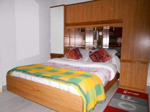 Schlafzimmer mit einem Bett mit einem Kopfteil aus Holz in der Unterkunft t2 bord de mer au calme in Bandol