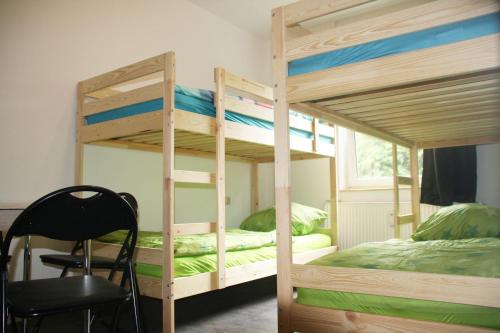 a bedroom with two bunk beds and a chair at Apartmenthaus am Rennplatz in Bremen