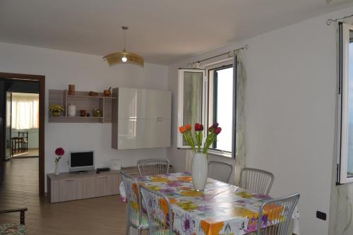 a dining room with a table with a vase of flowers on it at Il Terrazzo su Pizzo in Pizzo