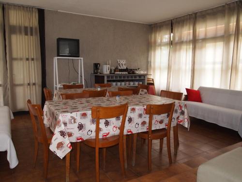 a dining room with a table and chairs and a couch at Lake Vendégház in Alsóörs