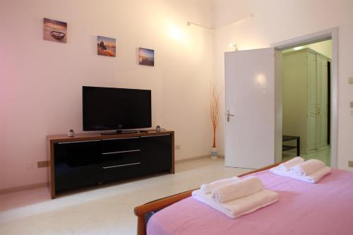 Schlafzimmer mit einem Flachbild-TV und einem Bett in der Unterkunft Casa Amalia in Lecce