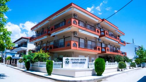 un edificio de color naranja y blanco en Milonas House Apartments, en Paralia Dionisiou