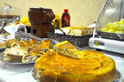 a table topped with plates of bread and pies at Hotel Platanus in Campos do Jordão