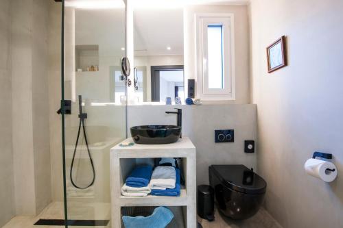 y baño con ducha acristalada y lavamanos. en Kook Hotel Tarifa en Tarifa