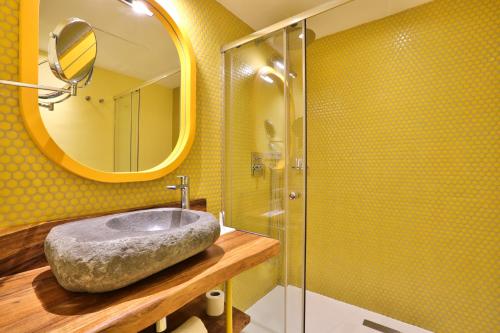 a bathroom with a stone sink and a mirror at Paradiso Ibiza Art Hotel - Adults Only in San Antonio Bay