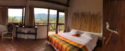 a bedroom with a bed and a balcony with a view at Akawanka Lodge in San Agustín