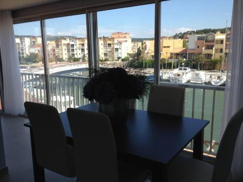 - une table à manger avec des chaises et une vue sur le port dans l'établissement Les Satines, à Gruissan