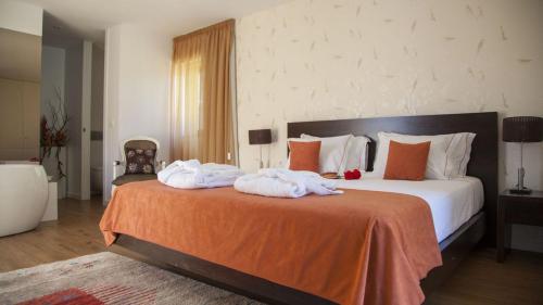 a bedroom with a large bed with towels on it at Quinta Da Mouta in Vieira do Minho