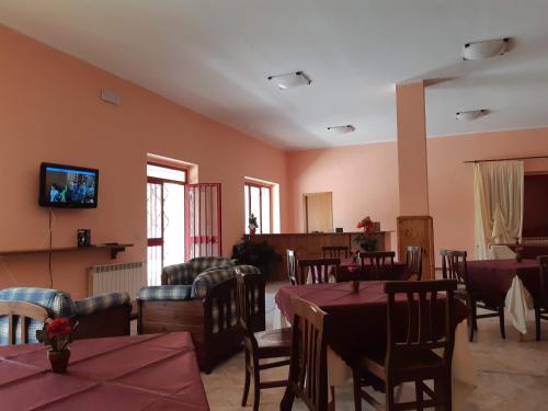 a dining room with tables and chairs and a tv at Rifugio dei Sanniti in Borrello