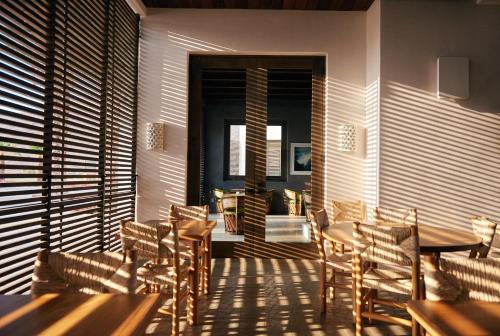 a dining room with wooden tables and chairs at Hotel San Cristobal Adults 15+ in Todos Santos