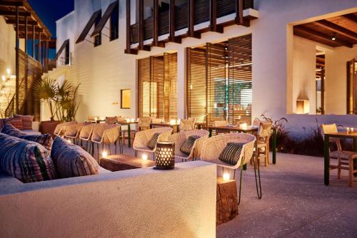 a restaurant with couches and tables and lights at Hotel San Cristobal Adults 15+ in Todos Santos