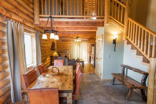 ein Esszimmer mit einem Holztisch und einer Treppe in der Unterkunft Zion Mountain Ranch in Mount Carmel Junction