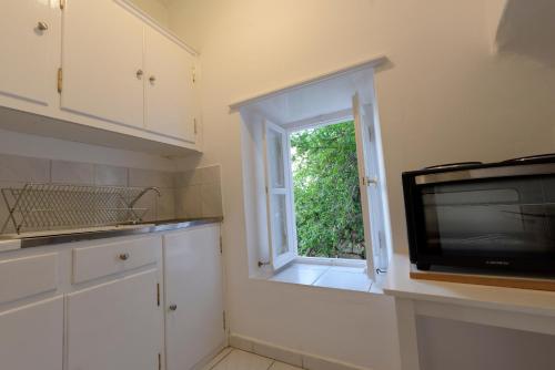 a kitchen with a tv and a window in it at Bahia in Hydra