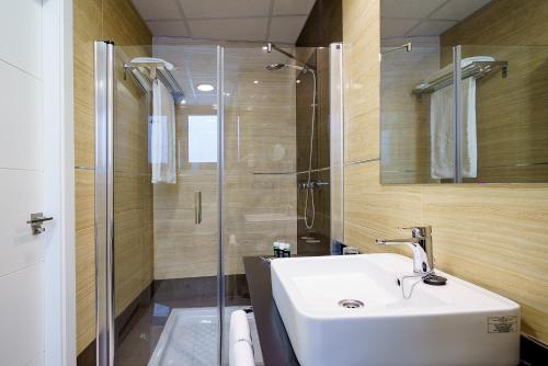 a bathroom with a white sink and a shower at Exe Málaga Museos in Málaga