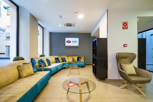 a living room with a couch and a table at Exe Málaga Museos in Málaga