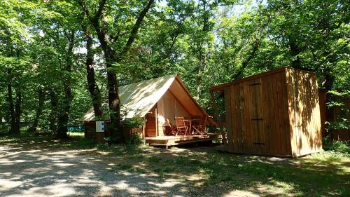 uma cabana de madeira no meio de uma floresta em Camping La Châtaigneraie em Gravières