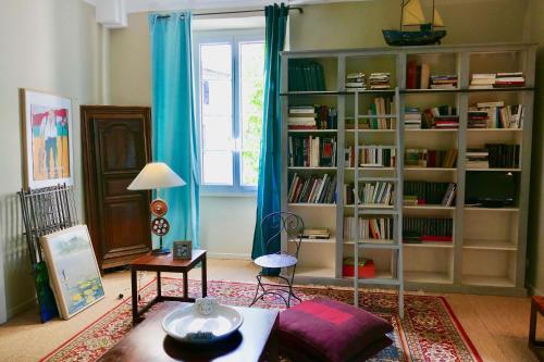 a living room with a book shelf filled with books at Hôtel de Mirmande in Mirmande
