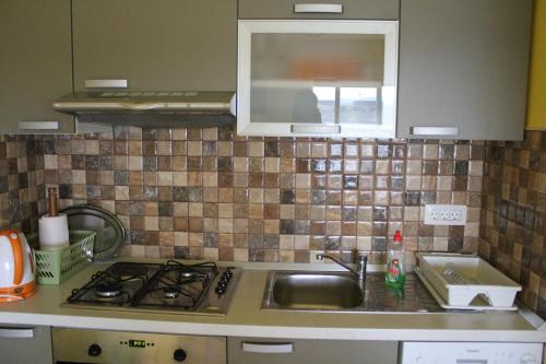 a kitchen counter with a sink and a stove at Primavera in Omišalj