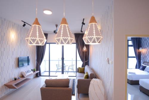 a living room with chandeliers and a room with a bed at Atlantis Residence @ Icon Stay Melaka in Malacca