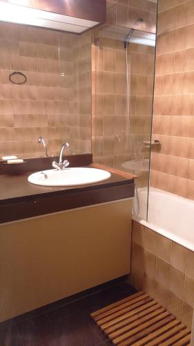 une salle de bain avec un lavabo, une douche et une baignoire dans l'établissement EN BORD DE MER, à Gruissan