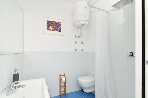 een witte badkamer met een toilet en een wastafel bij Casa Partenope in Ischia