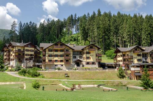 a large apartment complex with a lake and trees at Vila Renáta - Apartmán Renáta 12 in Ružomberok