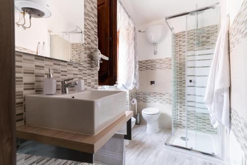 La salle de bains est pourvue d'un lavabo blanc et d'une douche. dans l'établissement Sa domu rubia, à Iglesias