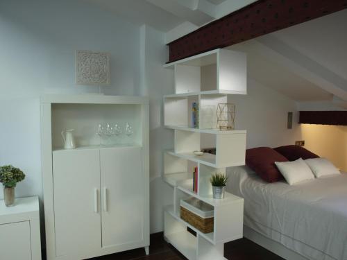 ログローニョにあるAtico Portales, Diseño en el casco antiguo de Logroñoのベッドルーム(ベッド1台、白い棚付)