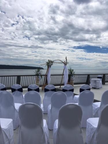a group of white chairs and a ceremony on a deck at Anchor Inn and Suites in Campbell River