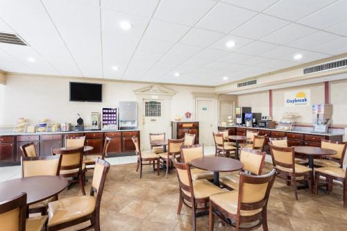 a restaurant with tables and chairs and a kitchen at Days Inn by Wyndham Goldsboro in Goldsboro