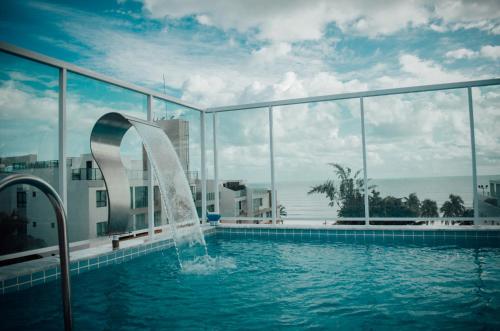 uma piscina com uma fonte em frente a um edifício em Oriental Praia Hotel em João Pessoa
