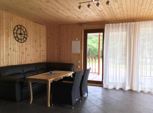 a living room with a table and a couch and a window at Dīķmalas in Roja