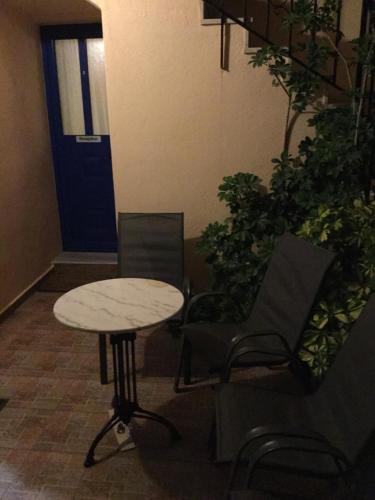 a table and chairs in a room with a door at Eugenia travasarou sea view appartments in Dhiakofti