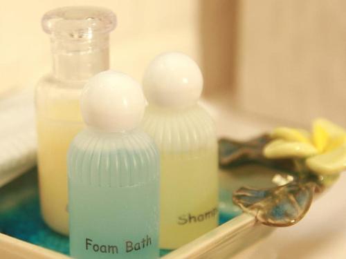 two soap bottles sitting on top of a bathroom mirror at The Great Residence Suvarnabhumi Airport in Lat Krabang