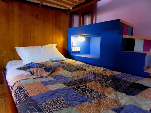 a bedroom with a bed with a blue head board at Pátio das Andorinhas in Ferreira do Alentejo